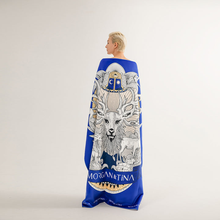 A woman wearing a Morgan&Tina blue personalized bath towel with a stag of the Yggdrasil on it.