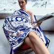 Load image into Gallery viewer, A woman is sitting in a chair reading a magazine while draped in a Morgan&amp;Tina WORLD TREE design bath towel.
