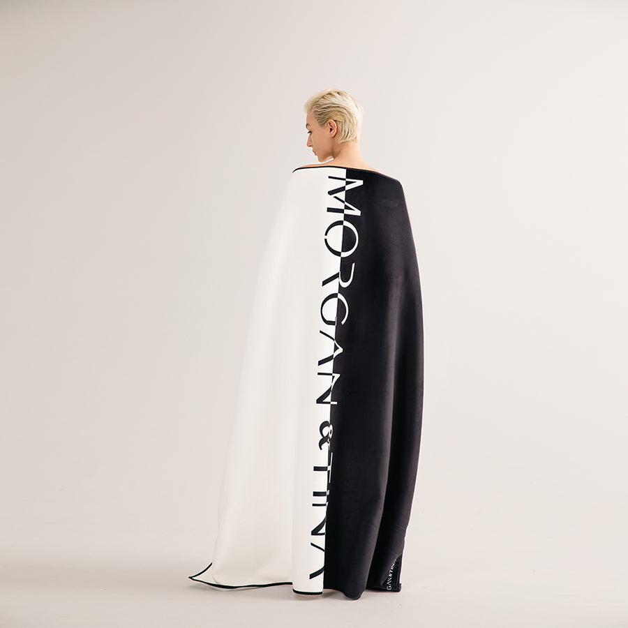 A woman wearing a Morgan&Tina black and white bath towel.